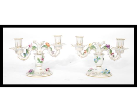 A pair of Dresden porcelain double sconce candelabras, each decorated with applied ceramic flowers and gilt motifs and raised