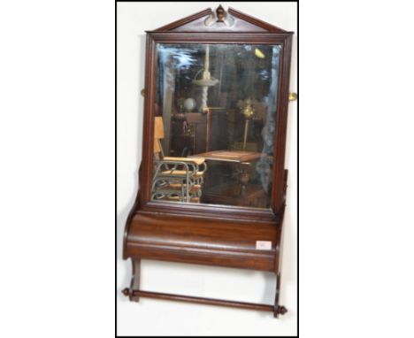 A Victorian 19th century mahogany wall mirror / towel rail having central mirror glass set over a hinged dome top covered she