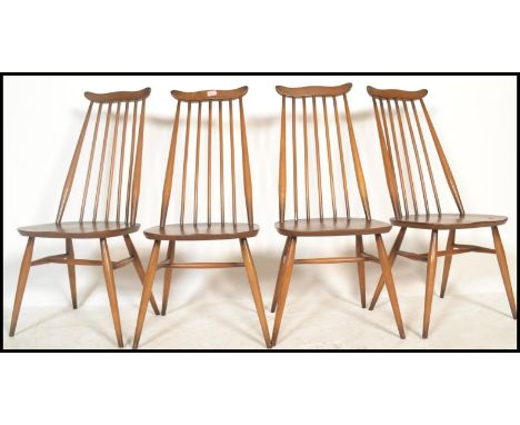 A set of four 20th century vintage Golden Dawn Ercol beech and elm stick back dining chairs, raised on tapering supports unit