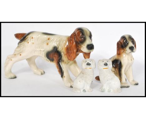 A pair of 19th Century Staffordshire ceramic dog figurines modelled as&nbsp;poodles together with a ceramic figurine of a Spa