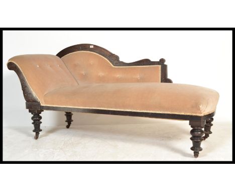 A late 19th century Victorian ebonised mahogany chaise longue - sofa day bed being raised on turned legs with brown ceramic c