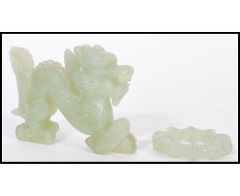 A Chinese Jade carved figurine of a dragon along with a carved jade bangle of typical form. Dragon measures 7cm-high 10cm-wid