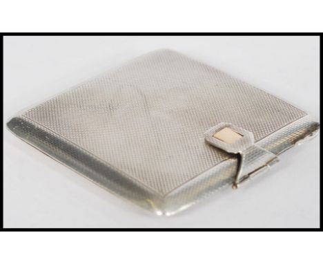 A hallmarked silver compact of square form having engine turned decoration with gold clasp. Hallmarked to the clasp. Weighs 8