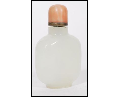A 19th century Chinese white / light green jade snuff bottle with red coral top complete with dabber. Measures 9cms-high.