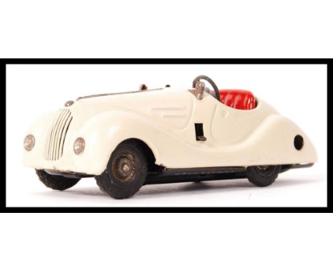 A vintage Schuco German tin plate clockwork toy&nbsp;model&nbsp;car 4001 Examico in a cream colour with red coloured seat. Ap