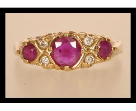 A hallmarked 9ct gold ruby and diamond ring having three rubies with diamond spacers.&nbsp; Hallmarked Sheffield. Size M.5. W