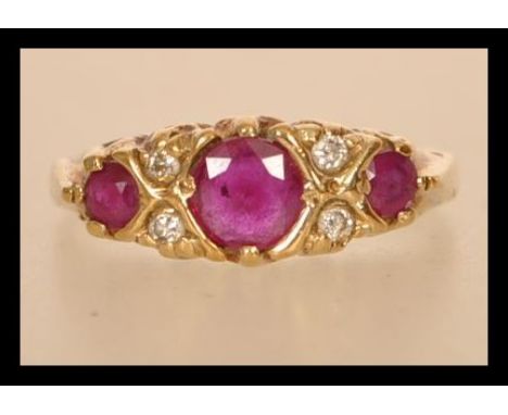 A hallmarked 9ct gold ruby and diamond ring having three rubies with diamond spacers.&nbsp; Hallmarked Sheffield. Size M.5. W