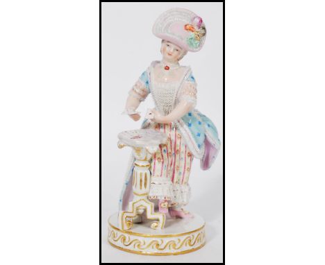 A late 19th century Meissen porcelain figure of a standing woman in 19th century costume by a tripod table playing cards, "Th