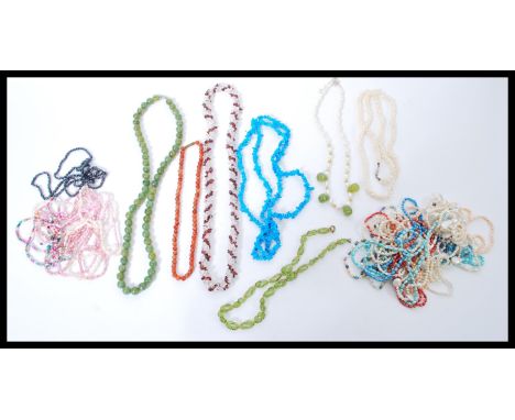 A selection of vintage necklaces to include a jade coloured hard stone necklace, a beaded red stone necklace, a strung blue a