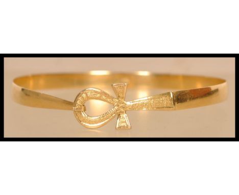 An 18ct gold Egyptian gold bangle bracelet having a Ankh hidden clasp. Egyptian hallmarks present to inside of band.