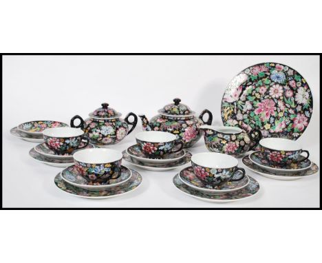 A vintage 20th century Chinese enamel hand decorated tea service consisting of teapot, cup saucer and side plate trios, sugar