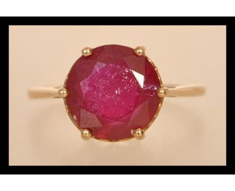 A 20th century stamped 375 gold yellow metal ring with a brilliant cut ruby in a prong and heart setting. Hallmarked Birmingh