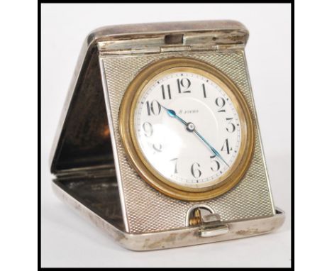 A silver 900 stamped travelling pocket watch clock having an engine turned case. The white enamel face having numeral chapter