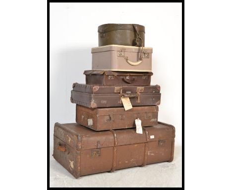 A stack of vintage suitcases to include canvas and wooden bound trunk, leather style suitcases, 1950's vanity cases etc