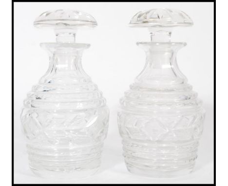 A pair of vintage 20th century cut glass crystal decanters of bulbous form complete with flat top mushroom stoppers.