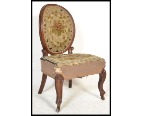 A 19th Century Victorian mahogany framed nursing chair having green and red needlework panels to the back and seat, with cera