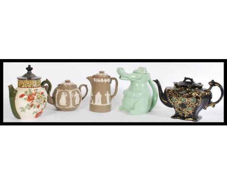 A collection of 20th century tea pots, a Doulton Lambeth stoneware tea pot and coffee pot with white raised detailing having 