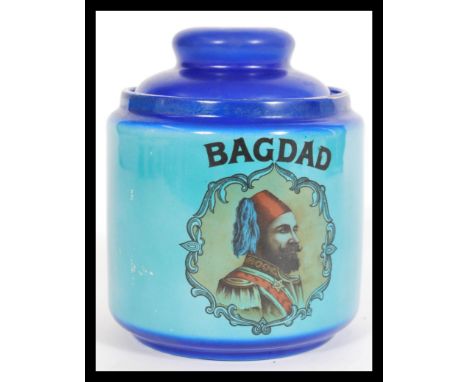 A vintage 20th century blue tobacco jar reading Bagdad, featuring a portrait of a middle eastern monarch with a cobalt shaped