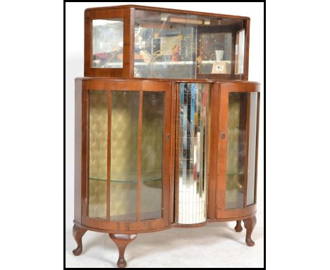 A vintage early 20th Century walnut glazed cocktail cabinet, the cabinet  having a central mirrored revolving bottle holder f