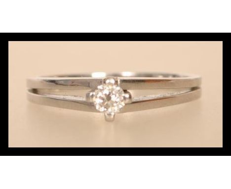 A 14ct white gold 585 stamped solitaire diamond ring having a central diamond in claw setting with split shoulders. Diamond a