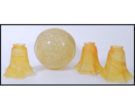 A group of retro vintage 20th century lamp shades to include a yellow mottled glass spherical lamp shade and a group of three