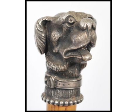 A 20th Century walking cane, the Malacca stick surmounted with a white metal cast figural dog. 85cm long.&nbsp;