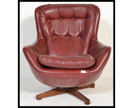 An original 1960's retro vintage button back swivel egg type chair / armchair being raised on a four point splayed teak suppo