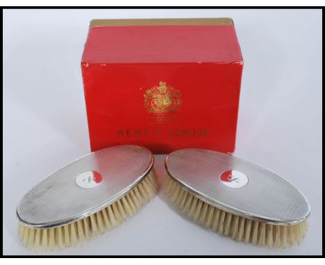 A cased pair of silver hallmarked brushes retailed by Kent of London complete in original box. Each brush having an engine tu