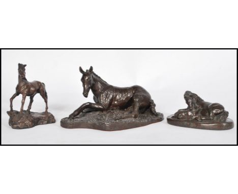 A collection of three bronzed effect sculptures modelled as horses / foals, to include a recumbent horse marked R F Alexander