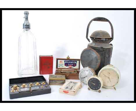A collection of vintage items to include a vintage early 20th century railway lamp, vintage alarm clocks, advertising maps so