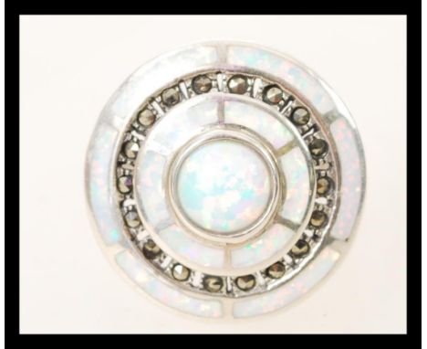 A silver Art Deco style ring having concentric circular opal panels to the head with inset marcasites. Size Q. Weight 8.6g.