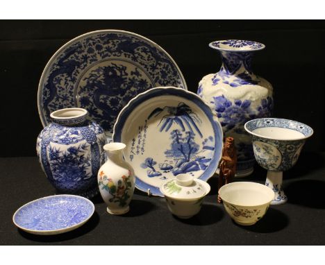 A Chinese inverted baluster blue and white vase, moulded in relief with a dragon trailing through painted leafy blossom, 28cm