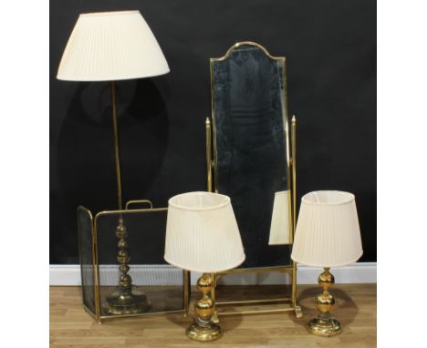 A brass cheval mirror, 138cm high; a pair of brass table lamps, the column as three graduating orbs; a brass standard lamp; a