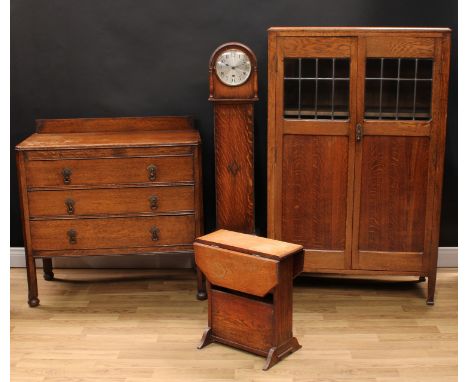 An oak press cupboard or bookcase, rectangular top with moulded edge above a pair of quarter-glazed doors enclosing three adj