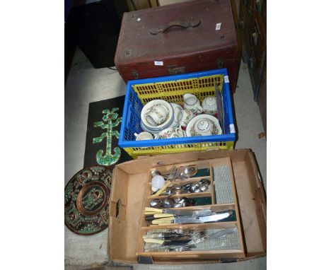 A small leather bound trunk with contents to include: china, cutlery and plaque.
