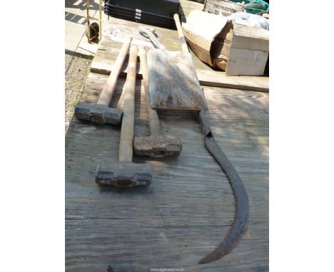 Three sledge hammers, a spade and a scythe.