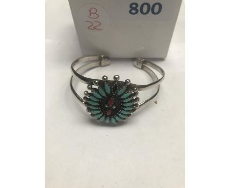 A SILVER AMERICAN TURQUOISE STONE BANGLE (ONE STONE MISSING) 