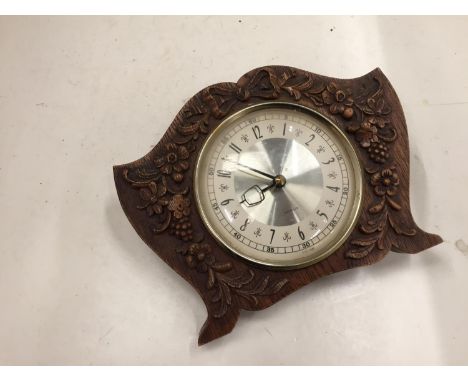 A WOODEN WESTCLOX MANTLE CLOCK WITH A FLORAL CARVED FRONT 