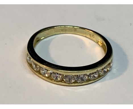 A 9 CARAT GOLD RING WITH NINE IN LINE CLEAR STONES SIZE K 