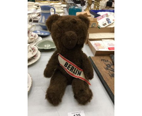 A VINTAGE- POSSIBLY STEIFF - BERLIN BROWN BEAR WITH A BERLIN SASH.  HEIGHT 26CM 