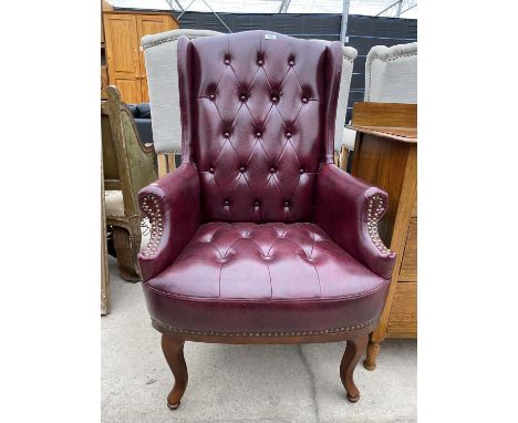 AN OXBLOOD WINGED BUTTON-BACK CHAIR 