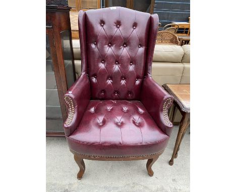 AN OXBLOOD WINGED BUTTON-BACK CHAIR 
