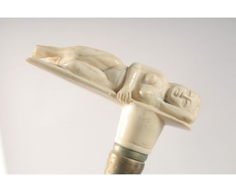 A WALKING STICK WITH CARVED BONE HANDLE as a nude.