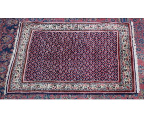 A PERSIAN RUG, dark blue ground central panel with stylised Boteh decoration. 4'10" x 3'1"
