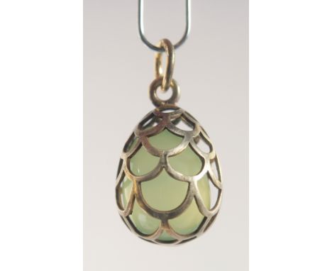 A SILVER AND JADE EGG SHAPED PENDANT, of cage design. 2cm high
