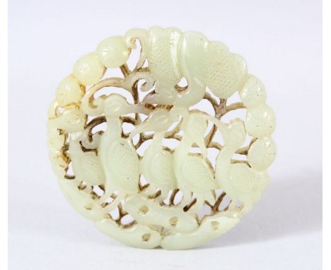 A CHINESE CARVED JADE DISK / PENDANT - Carved with birds aside foliage. 6.5cm.