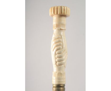 A WALKING STICK WITH CARVED BONE HANDLE as clasped hands.