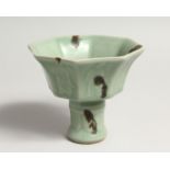 A CHINESE GREEN STEM CUP octagonal on a circular base.