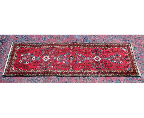 A PERSIAN RUNNER, bright red ground with stylised floral design. 6'8" x 2'2"
