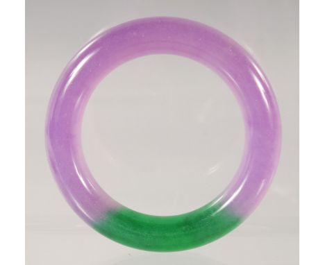 A CHINESE LAVENDER AND GREEN JADE BANGLE 8.5cm diameter.